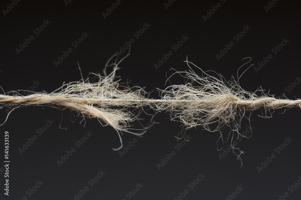 Fototapeta premium Frayed rope ready to break on dark background