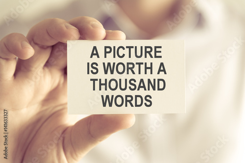 Businessman holding A PICTURE IS WORTH A THOUSAND WORDS message card photo