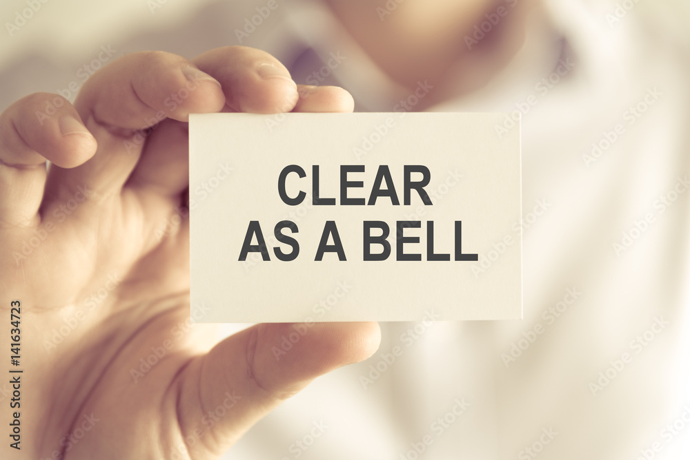 Businessman holding CLEAR AS A BELL message card Businessman holding CLEAR AS A BELL message card