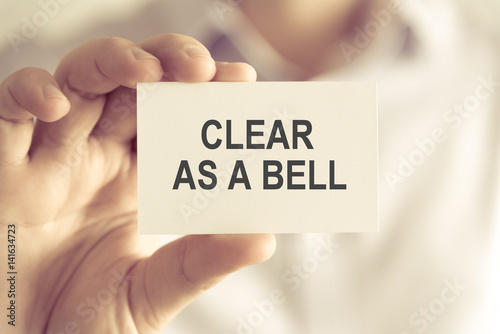 Businessman holding CLEAR AS A BELL message card