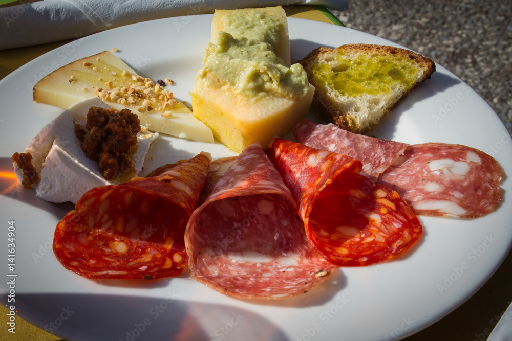 Antipasto di montagna con vari tipi di salami, polenta con purea di