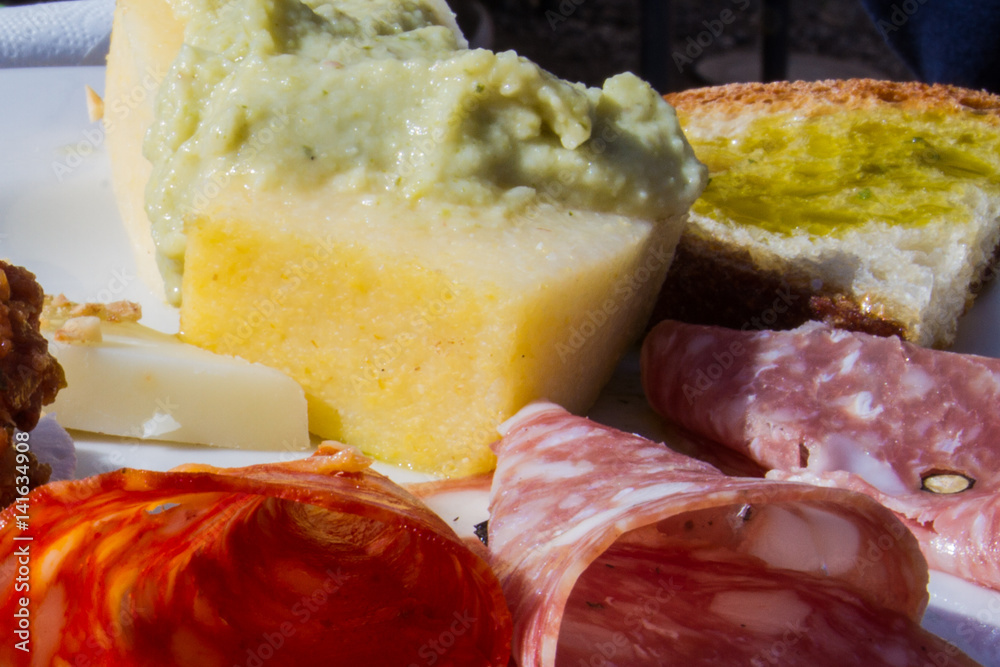 Antipasto di montagna con vari tipi di salami, polenta con purea di