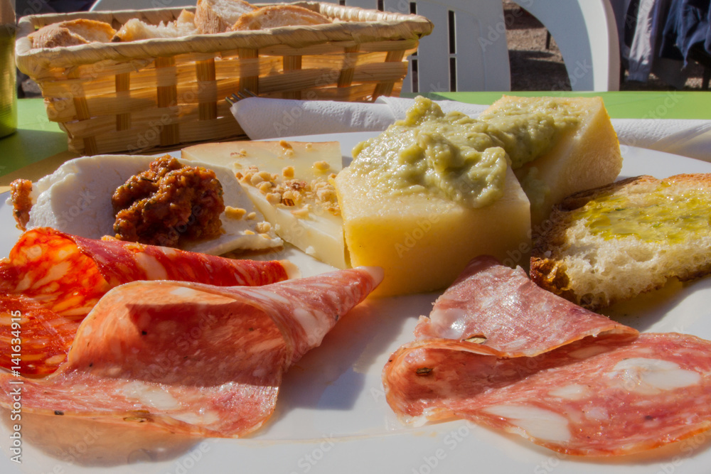 Antipasto di montagna con vari tipi di salami, polenta con purea di