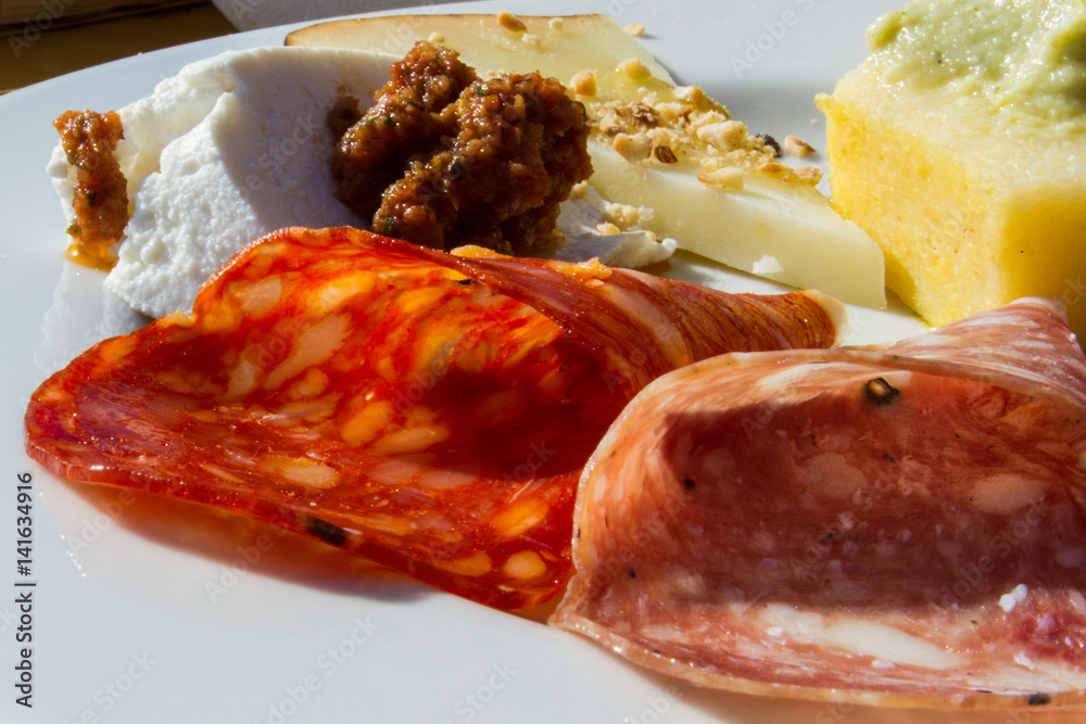 Antipasto di montagna con vari tipi di salami, polenta con purea di