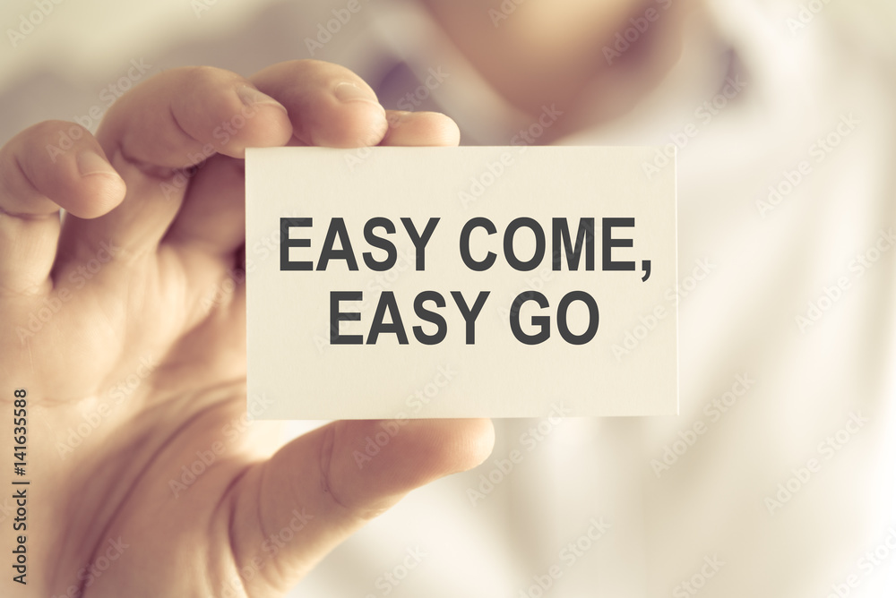 Businessman holding EASY COME, EASY GO message card Businessman holding EASY COME, EASY GO message card