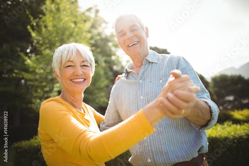Senior couple dancing in park