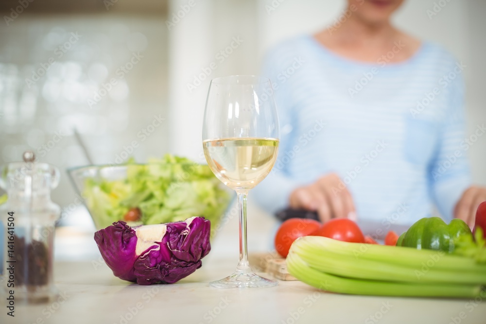 Glass of wine and vegetables on kitchen worktop