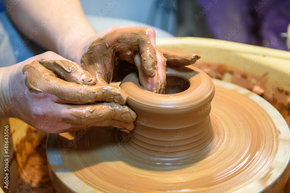 potter makes a pot of clay, working on the potter's wheel.
