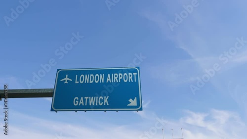 london gatwick airport sign airplane passing overhead photo