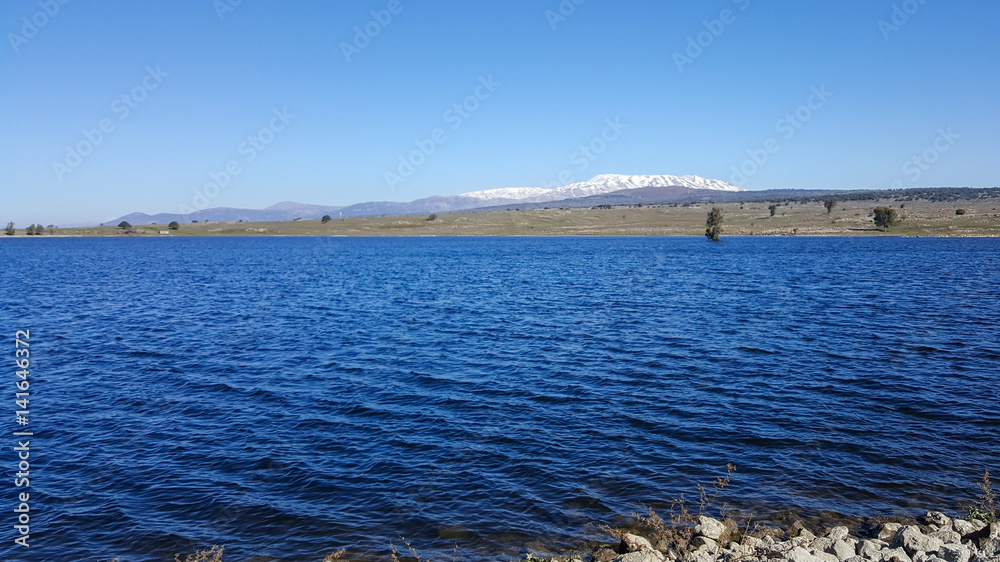 Panoramic landscape of blue lake and mountain Hermon background, Israel