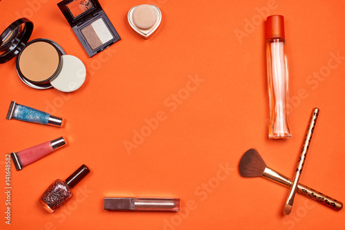 Flat lay, top view feminine table desk isolated on white. Workspace with cosmetics, phone, glasses, lipstick, nail lacquer, watches, mascara and eyeshadow in gold. Golden and black tones.