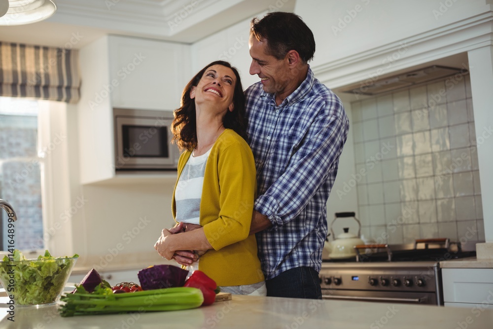 Obraz premium Couple embracing each other in kitchen