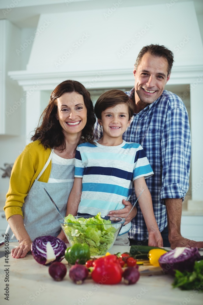 Portrait of parents and son preparing salad in kitchen Portrait of parents and son preparing salad in kitchen