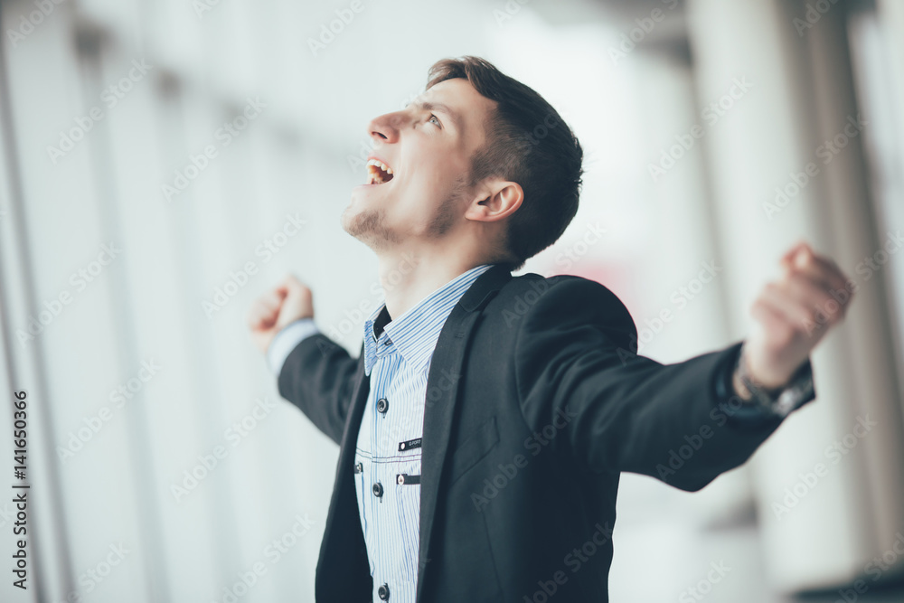 Business man with rised hands in his office. Victory sign. Business man with rised hands in his office. Victory sign.