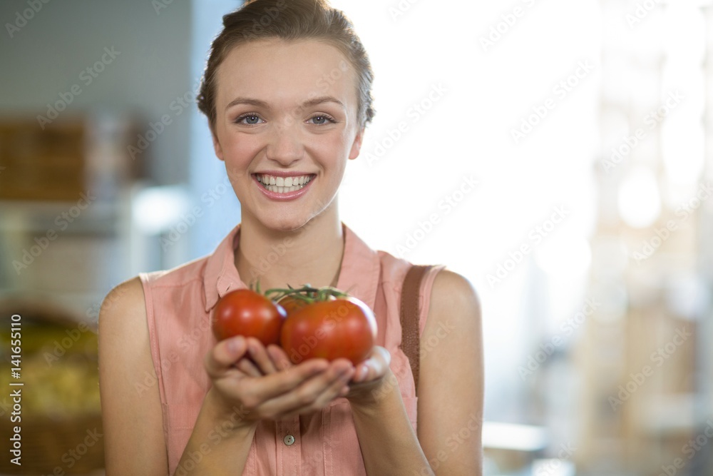 Woman holding tomatoes in grocery store Woman holding tomatoes in grocery store