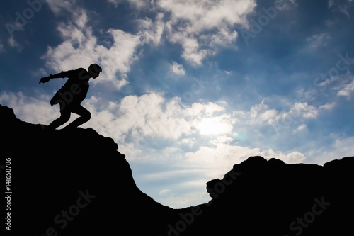 silhouette of man runing between rocks.