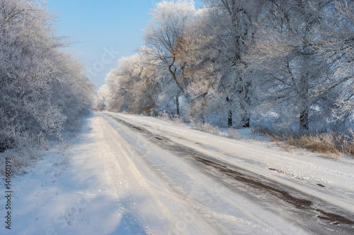 Winter landscape with slippery country road leading to Novo-Nikolaevka village in Dnepropetrovskaya oblast, Ukraine.