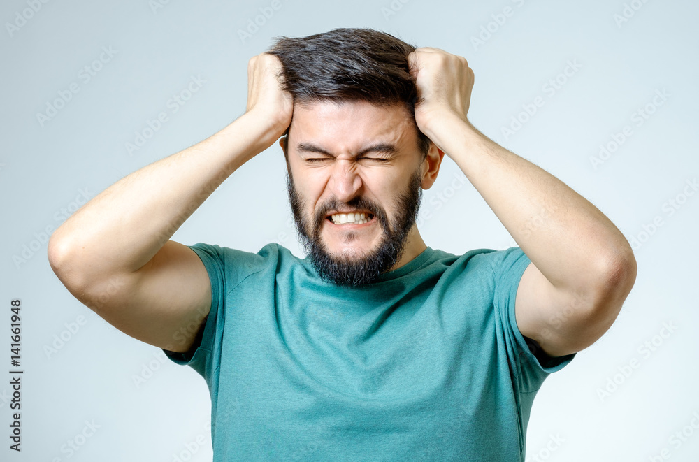 Depressed handsome bearded man touching having a headache Depressed handsome bearded man touching having a headache
