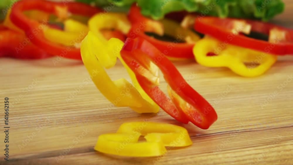 Slices of Ripe Peppers are Falling on Wooden Table. Slow Motion.
Slices of Ripe Peppers are Falling on Wooden Table. Slow Motion.