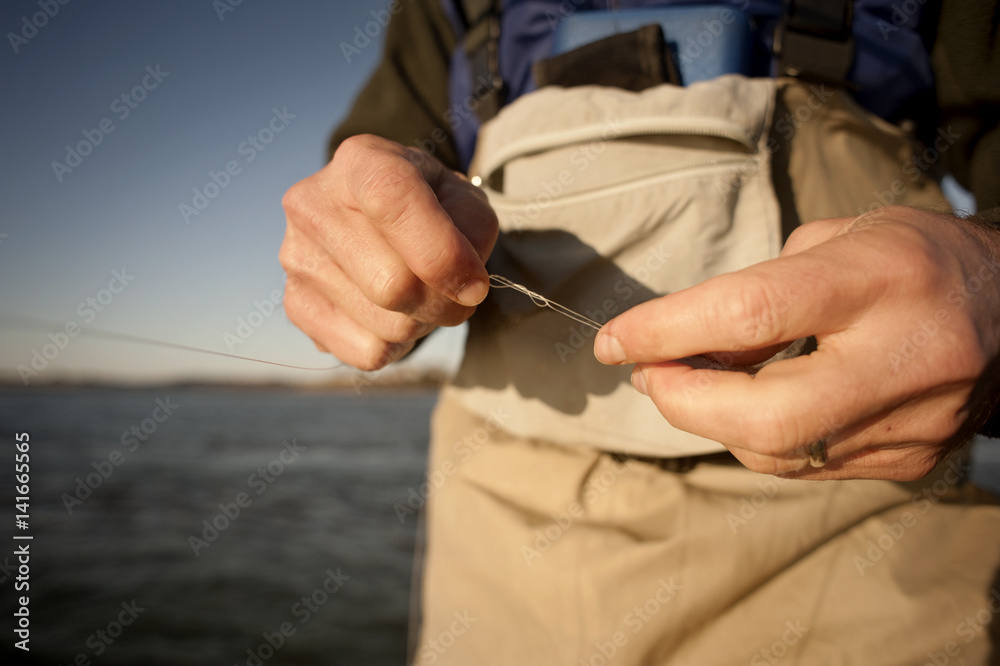 Midsection of man holding fishing line at beach