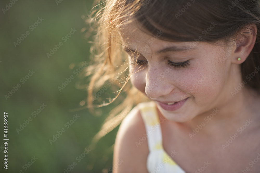 Close-up of girl looking down while standing on field Close-up of girl looking down while standing on field