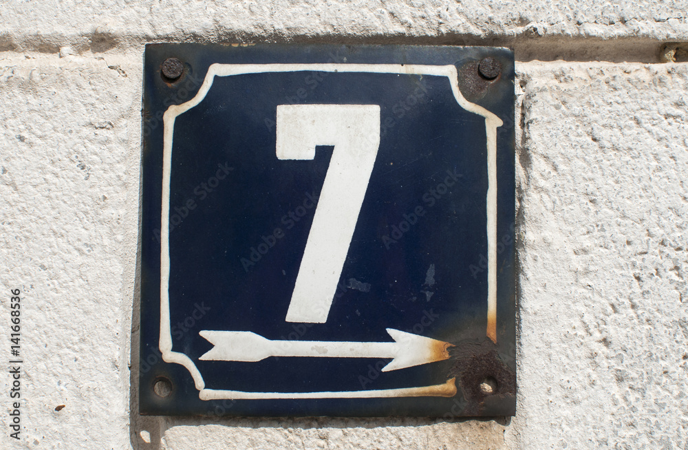 Weathered grunge square metal enameled plate of number of street address with number 7 closeup Weathered grunge square metal enameled plate of number of street address with number 7 closeup