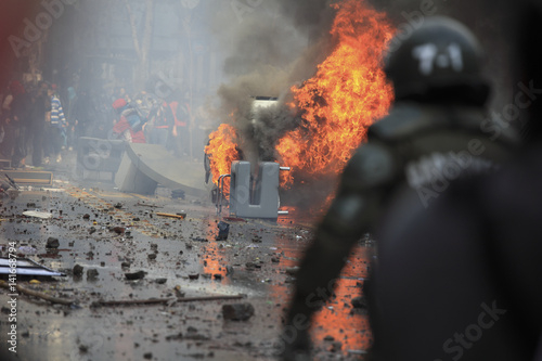 Fototapete Car overturned and burned
Street damage caused during a student strike in Santiago's Downtown, Chile
