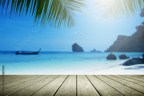Blurred beach background with palm tree and empty wooden.