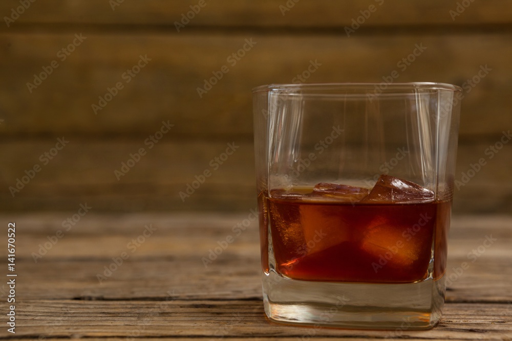 Glass of whisky with ice cube Glass of whisky with ice cube