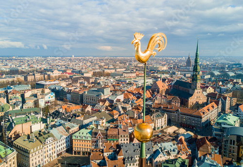 Beautiful aerial view of the old town in Riga, Latvia. With Dome Catherdal, St. Peters Church and golden cock in the foreground. Also Daugava river and TV Tower.