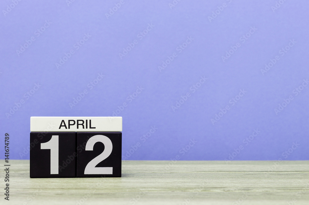 April 12th. Day 12 of month, calendar on wooden table and purple background. Spring time, empty space for text April 12th. Day 12 of month, calendar on wooden table and purple background. Spring time, empty space for text