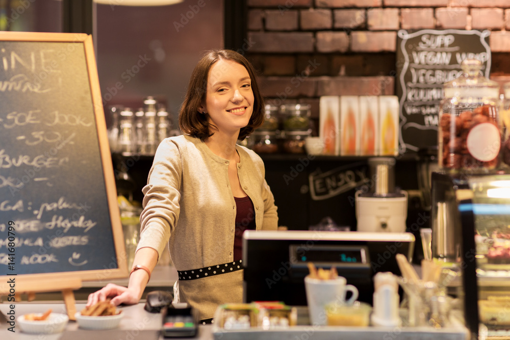 Fototapeta premium happy woman or barmaid at cafe counter