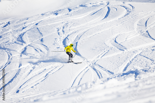 Sporty man skiing downhill in high mountains
