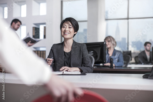 Smiling woman sitting at desk in city office