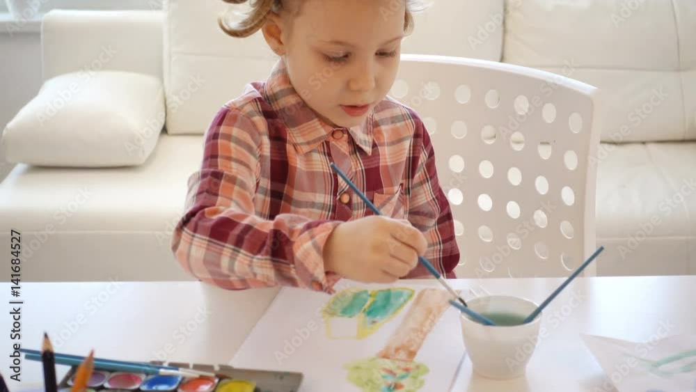 Pretty little child girl painting with colorful paint at home Pretty little child girl painting with colorful paint at home