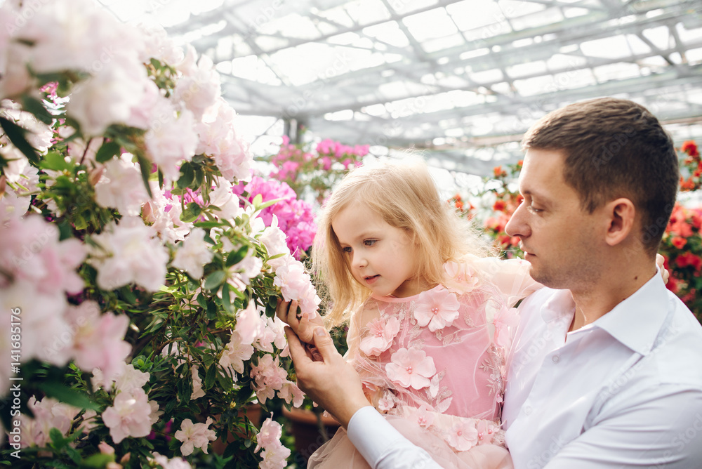 father holds a baby daughter in blossoming garden father holds a baby daughter in blossoming garden