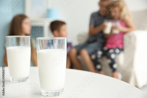 Glasses of milk on white table and blurred background