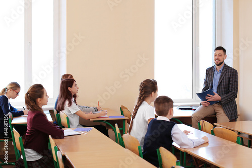 Pupils listening teacher in...