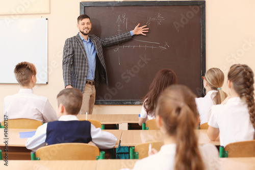 Pupils listening teacher in...