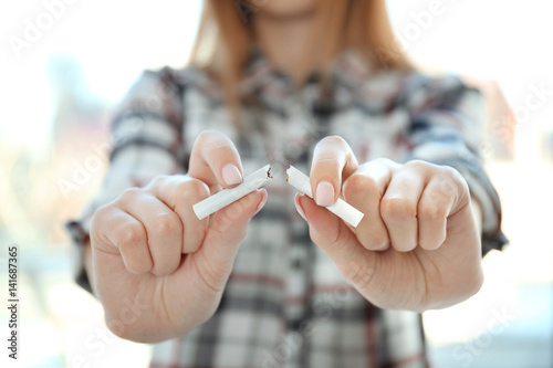 Closeup view of woman breaking cigarette in hands photo
