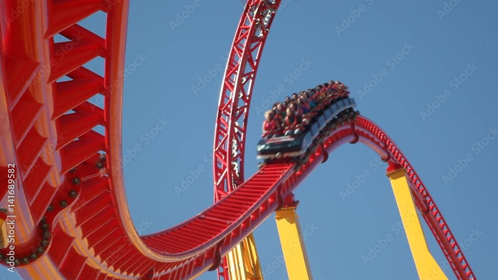 People ride a rollercoaster at an amusement park.