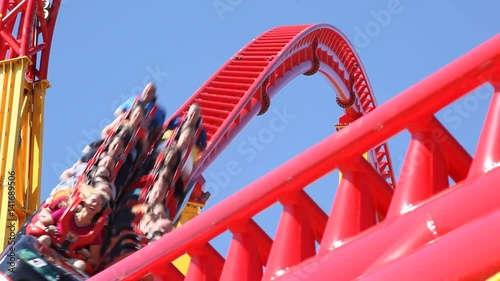 People ride a rollercoaster at an amusement park. photo