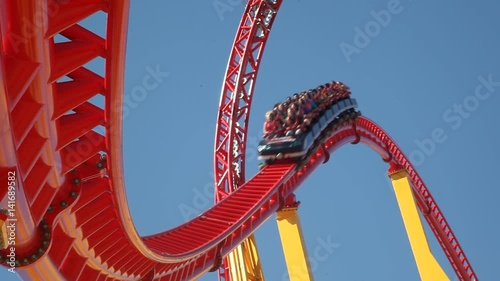 People ride a rollercoaster at an amusement park. photo