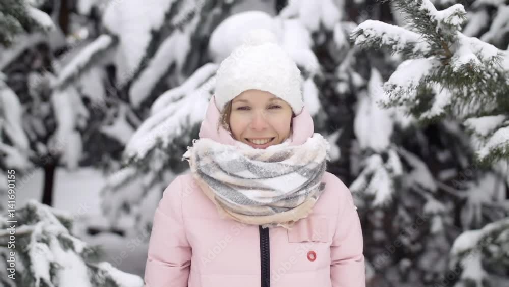 Portrait of a beautiful active girl in a winter forest, in the background a spruce in the snow slow mo Portrait of a beautiful active girl in a winter forest, in the background a spruce in the snow slow mo
