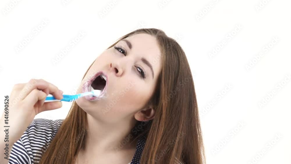 Woman dark long hair brushing cleaning teeth. Positive girl with toothbrush. Oral hygiene. Studio shot isolated on white background 4K ProRes HQ codec Woman dark long hair brushing cleaning teeth. Positive girl with toothbrush. Oral hygiene. Studio shot isolated on white background 4K ProRes HQ codec