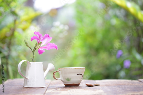 Butterfly Tree flower and tea cup on wooden table