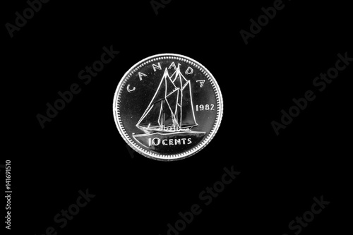A close up image of an old Canadian dime on a black background