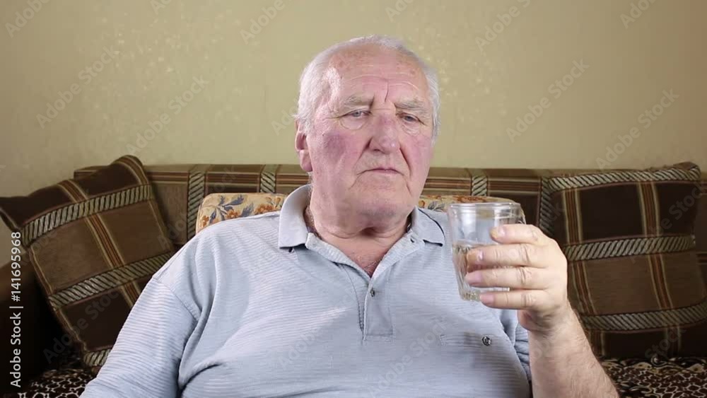 Elderly man drinking water from a glass. Elderly man drinking water from a glass.