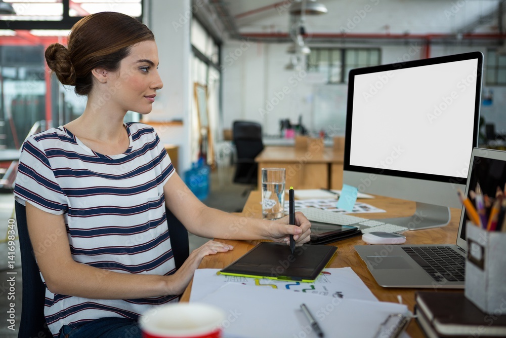 Graphic designer using graphic tablet and desktop Graphic designer using graphic tablet and desktop