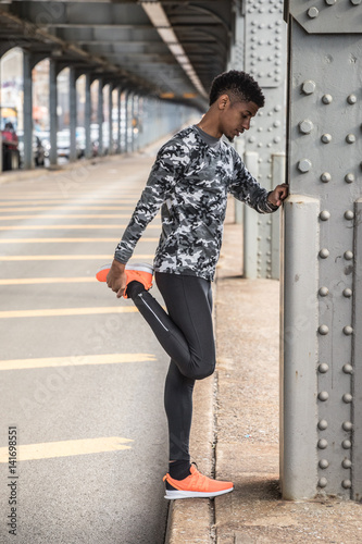 A young man stretches before going for a run in New York City © Erik
